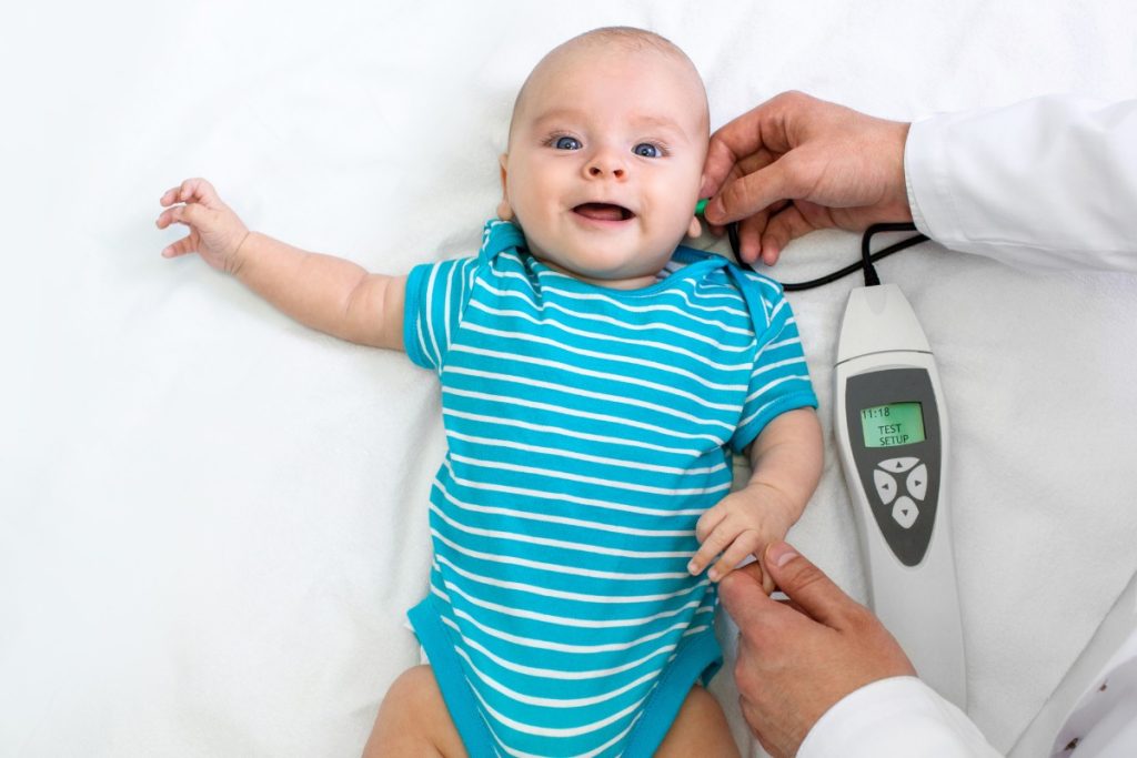 Çocuk odyologu, küçük bir hastayla oyun oynarken işitme testi yapıyor. Çocuk işitme, işitme testi, odyolog, pediatrik işitme.